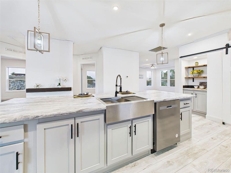 Functional island with farmhouse sink, high-arc black faucet, and integrated dishwasher—beautiful and efficient. Functional island with farmhouse sink, high-arc black faucet, and integrated dishwasher—beautiful and efficient.