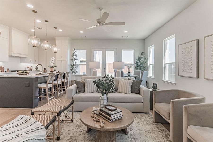 Living room with ceiling fan, light hardwood / wood-style flooring, french doors, and sink