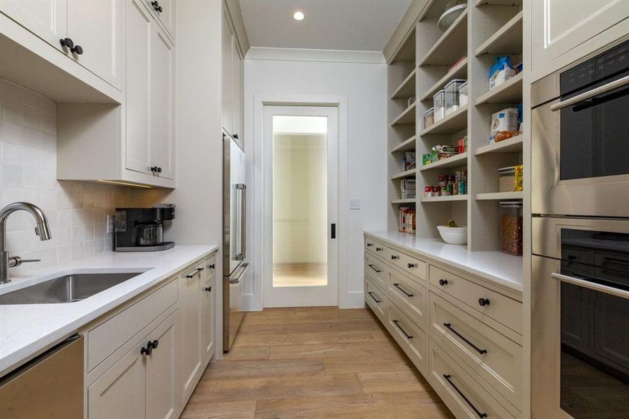 The walkthrough pantry provides a full fridge, another over, microwave, sink, dishwasher, nugget ice machine, and tons of storage!