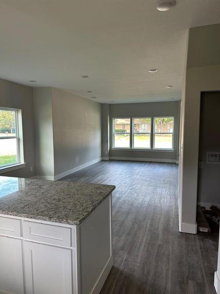 Hallway with dark wood-type flooring and baseboards