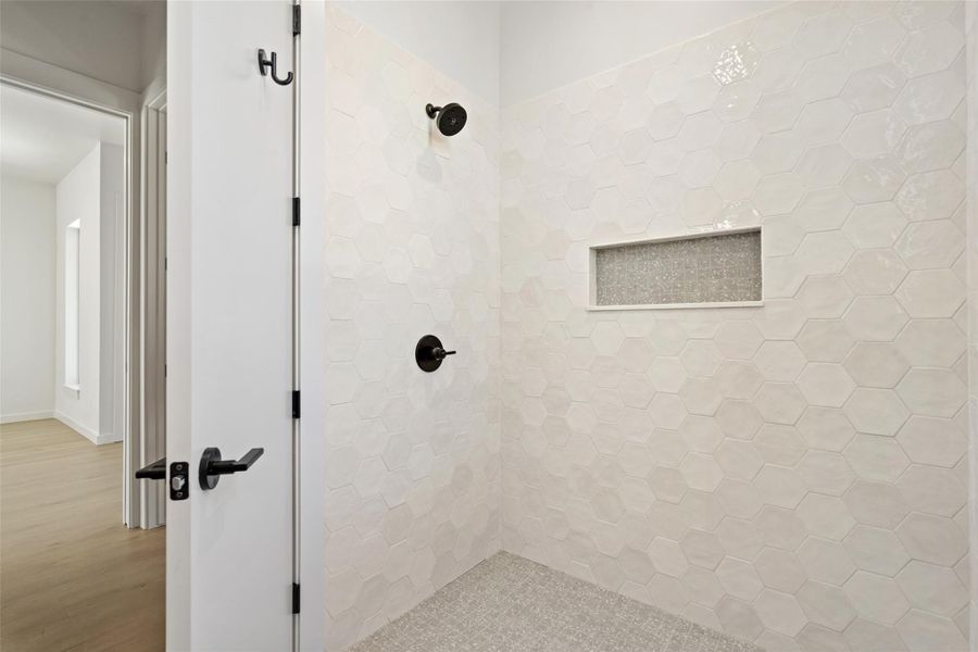 Bathroom featuring tiled shower and wood finished floors