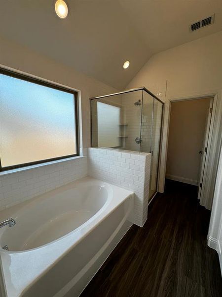 Bathroom with plus walk in shower, wood-type flooring, and lofted ceiling