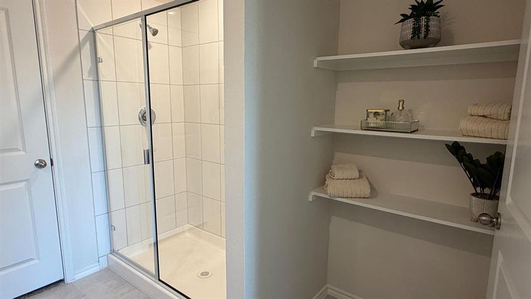 Full bathroom featuring a shower stall and a closet