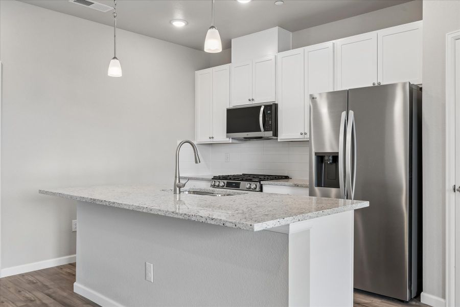 A kitchen with white cabinets.