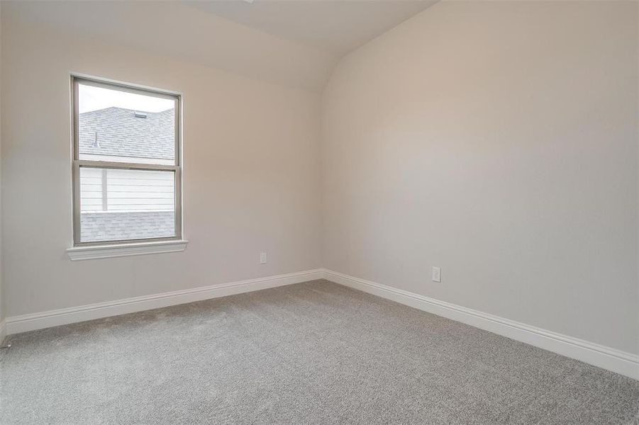 Unfurnished room with carpet floors and vaulted ceiling