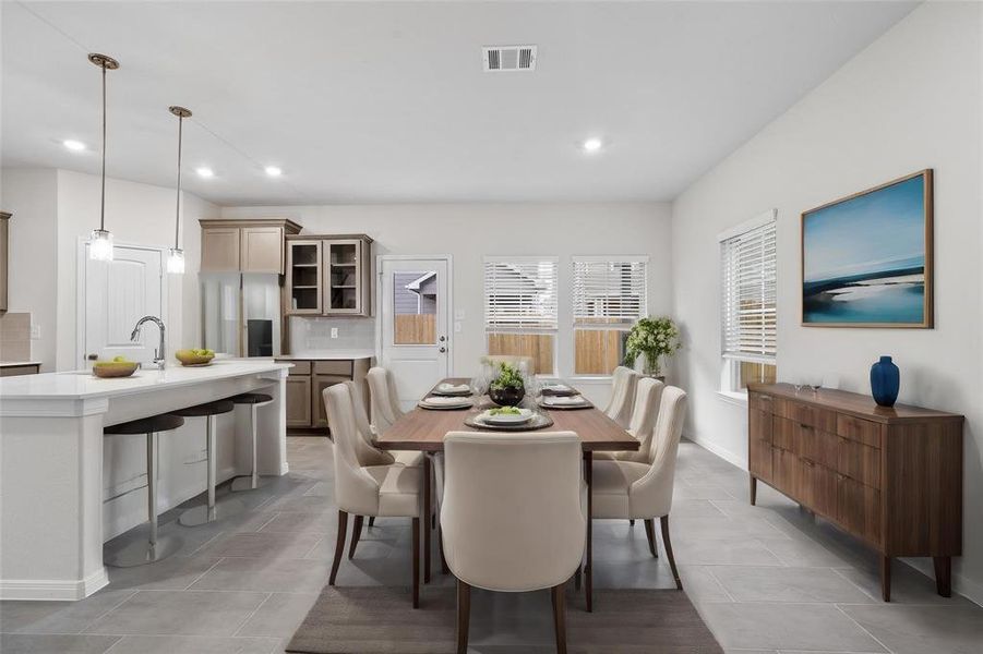 Entertain in style in this open-concept dining area, seamlessly connected to the kitchen. The bright and airy space is perfect for gatherings, featuring large windows that allow natural light to fill the room, creating a warm and inviting ambiance for meals with family and friends. **This image is from another Saratoga Home with similar floor plan and finishes, not the Brayden floorplan.**