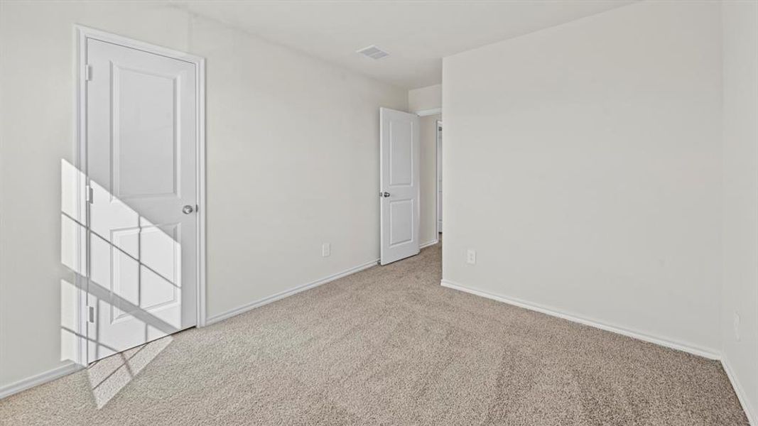 Unfurnished bedroom with carpet flooring and baseboards