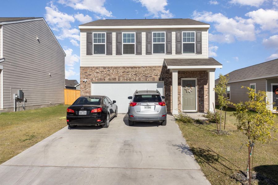 View of front facade with a garage and a front lawn