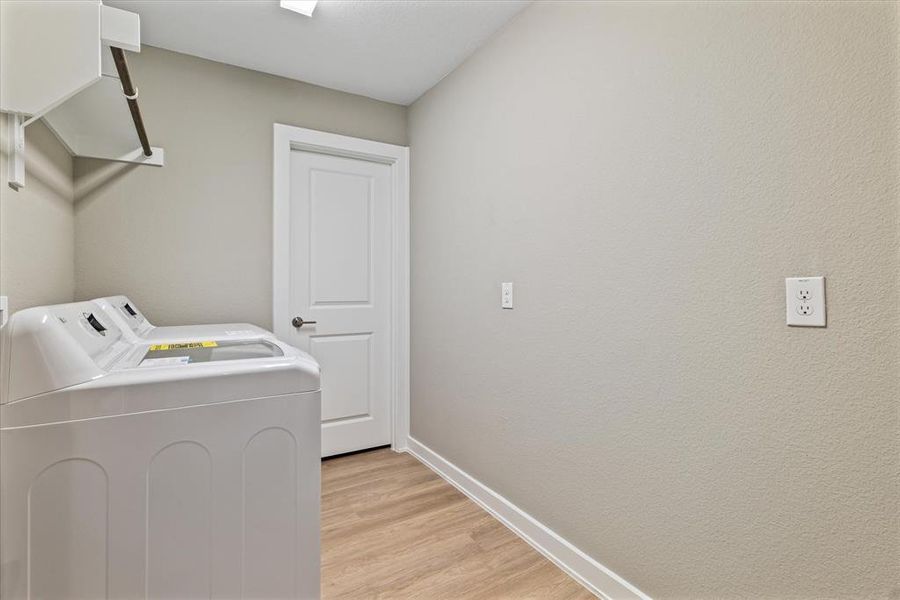 Clothes washing area featuring light wood-type flooring and washing machine and clothes dryer