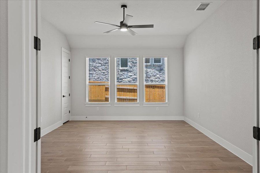 Empty room with light wood finished floors and ceiling fan Empty room with light wood finished floors and ceiling fan