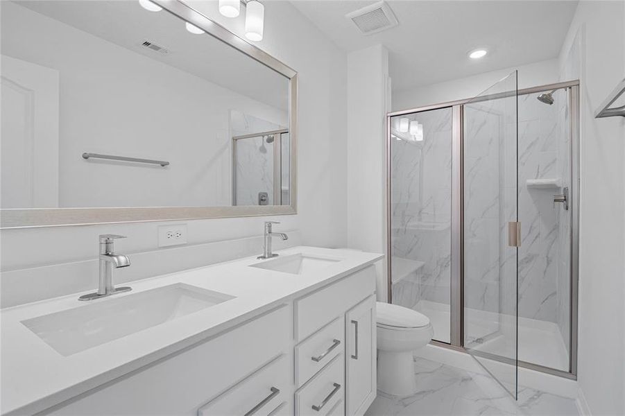 This primary bathroom is definitely move-in ready! Featuring an oversized walk in shower with seat and tile surround, stained cabinets with light countertops, dual vanities, framed mirrow, high ceilings, custom paint, sleek and modern finishes.