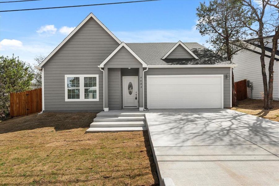 Ranch-style house with a front lawn, fence, roof with shingles, driveway, and an attached garage