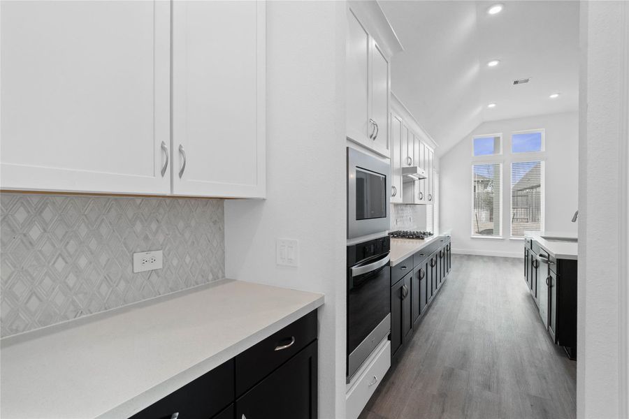 This gorgeous butler pantry area is perfect for quick access when entertaining friends and family. Featuring a popular "tuxedo" style, pairing crisp white upper cabinets with deep black lower cabinets to create visual depth and a modern aesthetic.