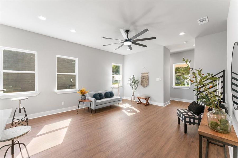Living area featuring light wood-type flooring, recessed lighting, and a ceiling fan