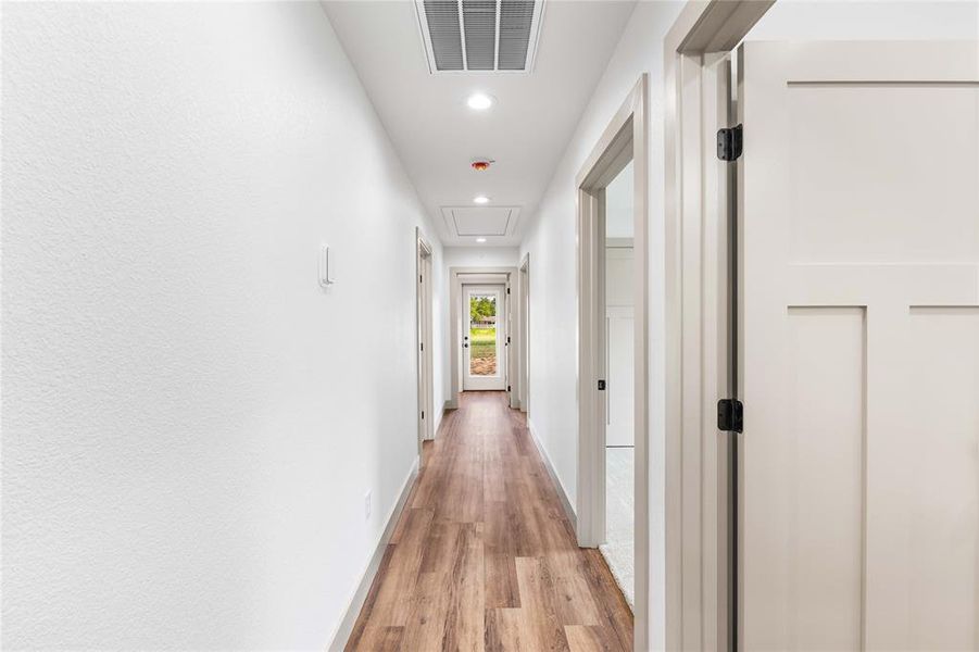 Corridor with light wood-style floors and recessed lighting Corridor with light wood-style floors and recessed lighting