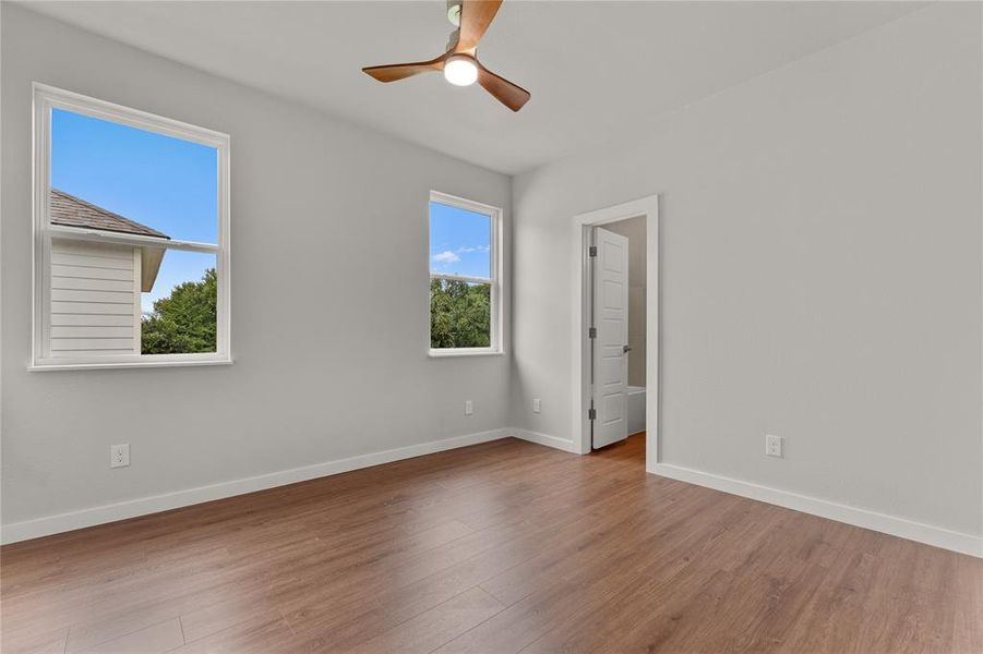 Empty room with wood finished floors and ceiling fan Empty room with wood finished floors and ceiling fan