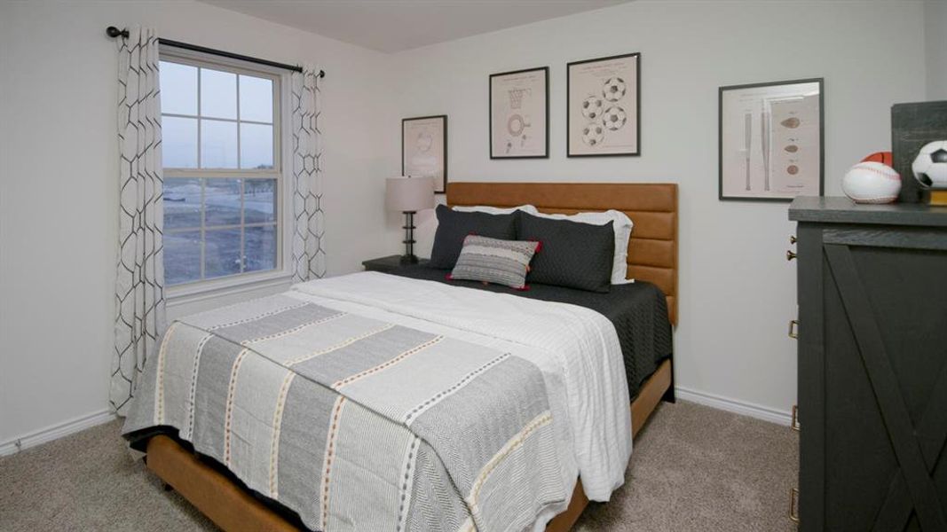 Bedroom featuring a window with grid pattern, neutral wall paint, and gray carpet flooring Bedroom featuring a window with grid pattern, neutral wall paint, and gray carpet flooring