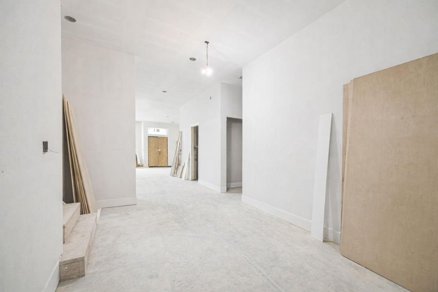 Expansive view from the entry of this Arch Angelo new construction, looking toward the rear of the home. This bright, open-concept floor plan features high ceilings and clean modern lines, seamlessly connecting the grand foyer to the main living areas. Large windows and glass doors provide abundant natural light and a clear sightline to the back of the property, showcasing the home's spacious layout and premium contemporary design. Expansive view from the entry of this Arch Angelo new construction, looking toward the rear of the home. This bright, open-concept floor plan features high ceilings and clean modern lines, seamlessly connecting the grand foyer to the main living areas. Large windows and glass doors provide abundant natural light and a clear sightline to the back of the property, showcasing the home's spacious layout and premium contemporary design.