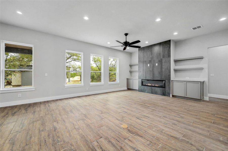 Unfurnished living room with a fireplace, wood finished floors, visible vents, and recessed lighting