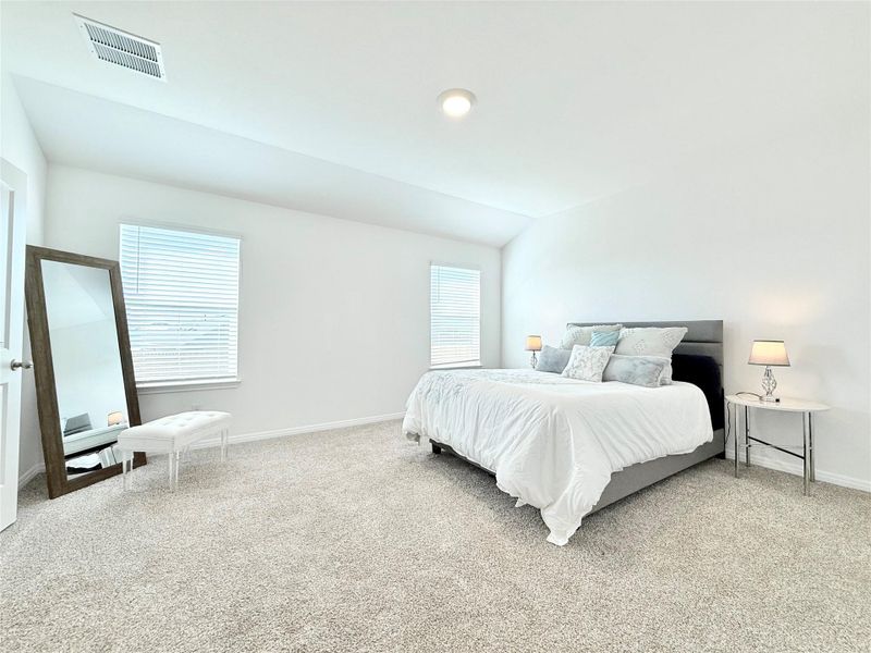 Bedroom featuring light colored carpet and vaulted ceiling Bedroom featuring light colored carpet and vaulted ceiling