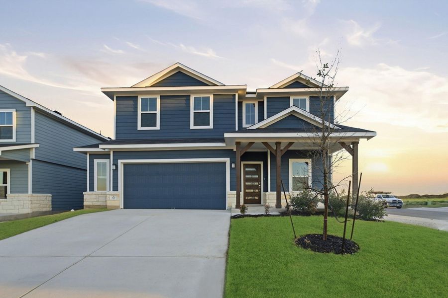 View of front of property featuring a front yard, driveway, an attached garage, and a porch