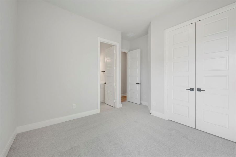 Unfurnished bedroom with carpet flooring, a closet, and ensuite bathroom