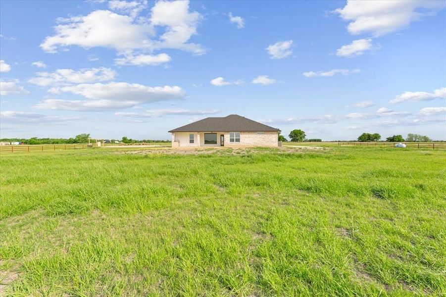 View of yard featuring a rural view and fence
