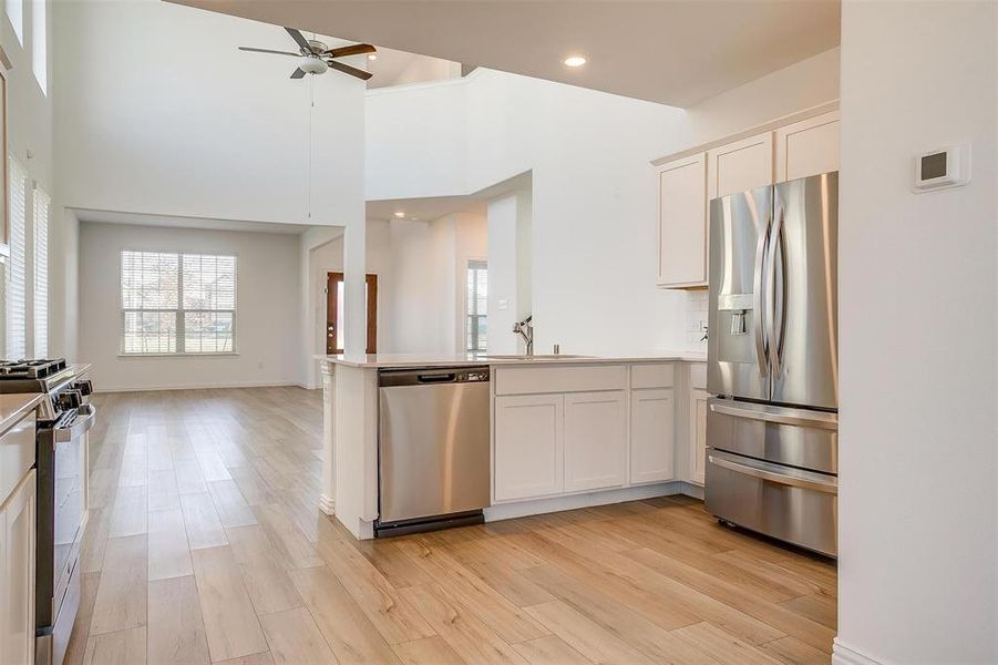 Kitchen featuring white cabinetry, light hardwood / wood-style flooring, and stainless steel appliances