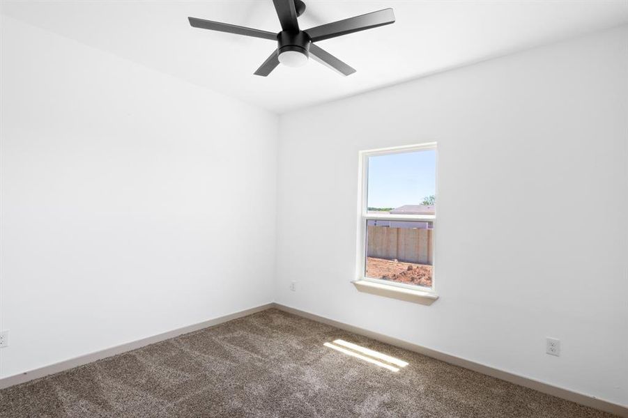Carpeted spare room featuring a ceiling fan and baseboards Carpeted spare room featuring a ceiling fan and baseboards