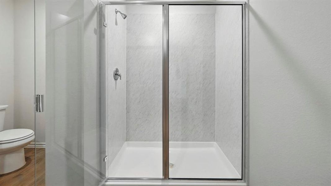 Full bath with a stall shower and wood finished floors