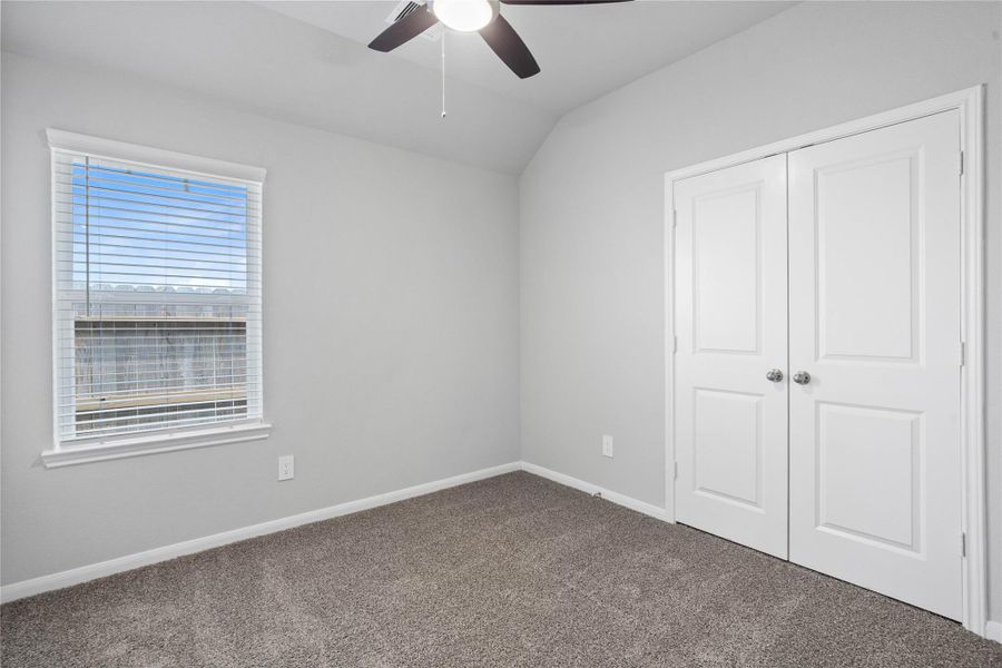 Perfect for guests or a quiet home office, this room features soft plush carpeting, a window with fitted blinds, sloped ceiling, and ample sized closet space.
