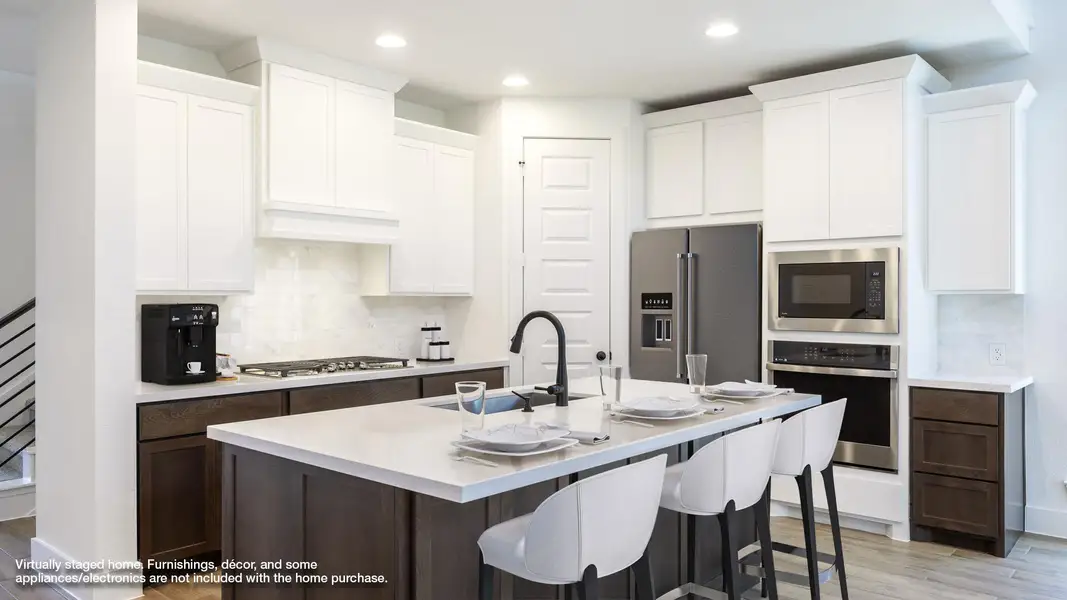 Kitchen with stainless steel appliances, backsplash, light wood finished floors, and a sink Kitchen with stainless steel appliances, backsplash, light wood finished floors, and a sink