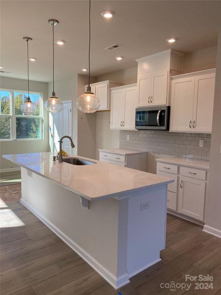 Actual Kitchen- quartz countertops, ceramic backsplash and white cabinets