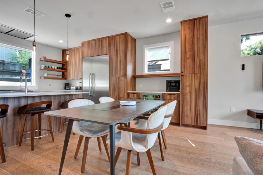 Dining space with light wood finished floors, plenty of natural light, and recessed lighting