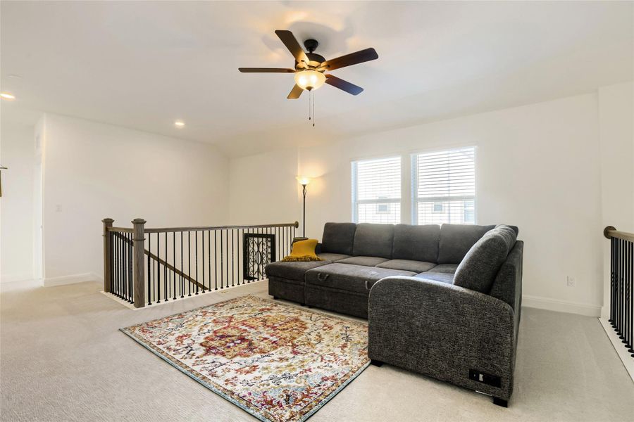 An inviting open-concept loft space offers abundant natural light and an overhead ceiling fan for comfort. An inviting open-concept loft space offers abundant natural light and an overhead ceiling fan for comfort.