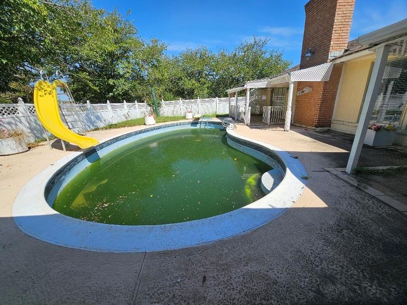 View of pool featuring a fenced backyard, a water slide, and a patio View of pool featuring a fenced backyard, a water slide, and a patio