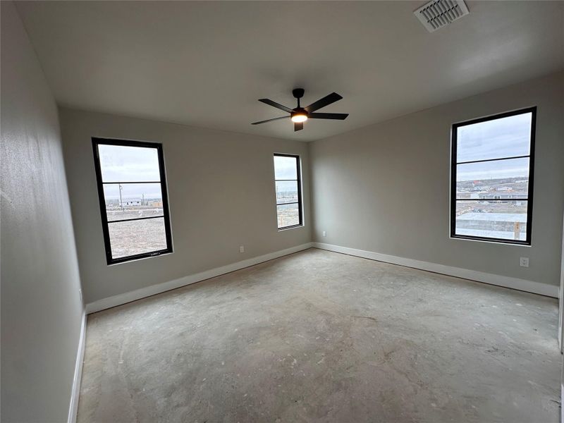 Unfurnished room with concrete flooring and ceiling fan