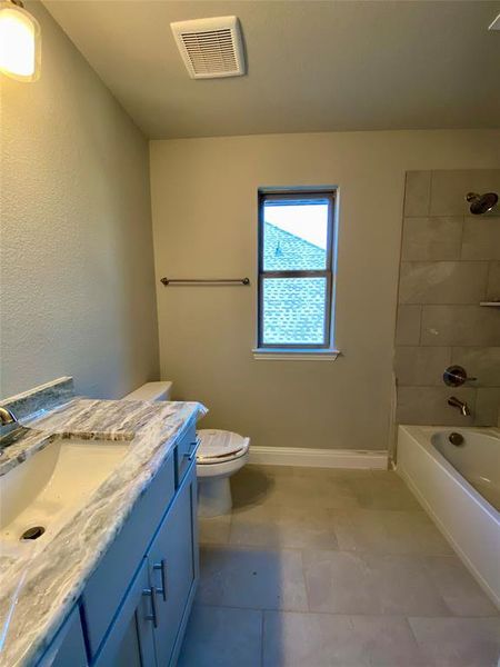 Bath 2 with window, granite counters, tub/shower, and 12x24 tile