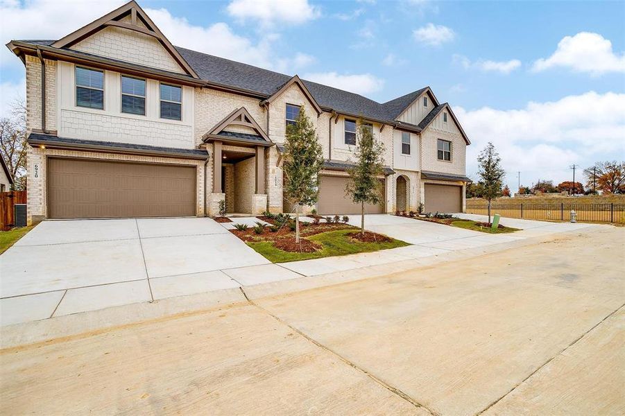 View of front of house with driveway, an attached garage, and fence