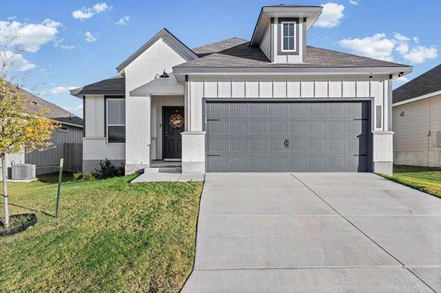 View of front of property with board and batten siding, roof with shingles, a garage, and concrete driveway View of front of property with board and batten siding, roof with shingles, a garage, and concrete driveway
