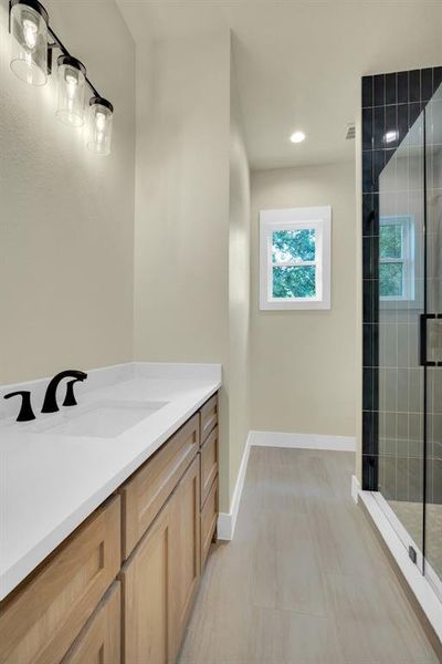 Bathroom with a shower with shower door, vanity, and tile patterned floors