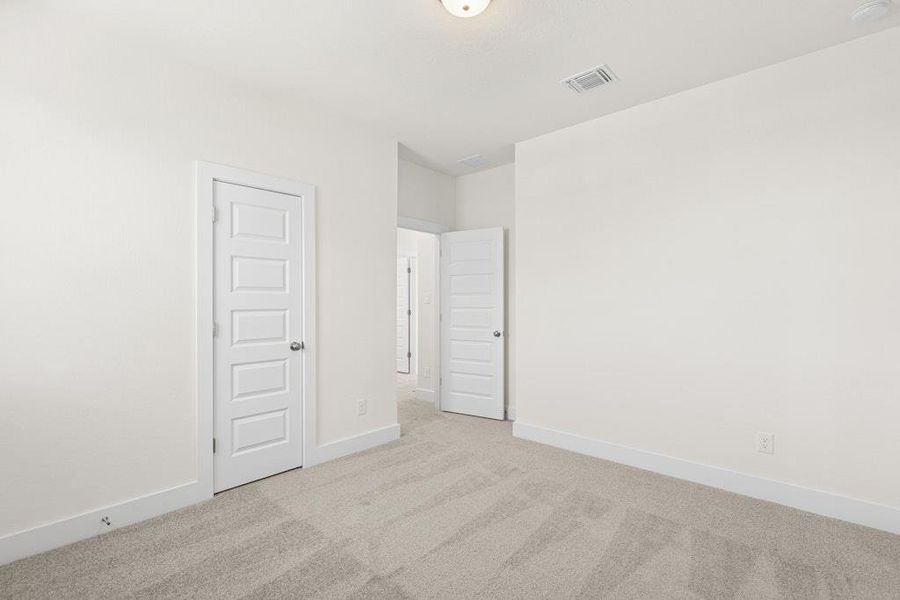 Unfurnished bedroom with light colored carpet and baseboards Unfurnished bedroom with light colored carpet and baseboards