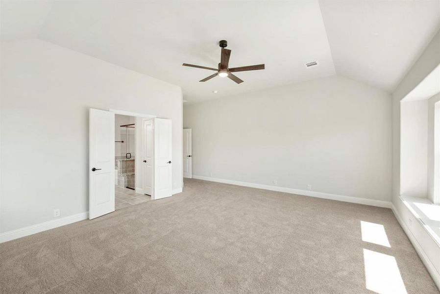 Spacious room featuring vaulted ceilings, a contemporary ceiling fan, light neutral carpeting, and a window seat with ample natural light Spacious room featuring vaulted ceilings, a contemporary ceiling fan, light neutral carpeting, and a window seat with ample natural light