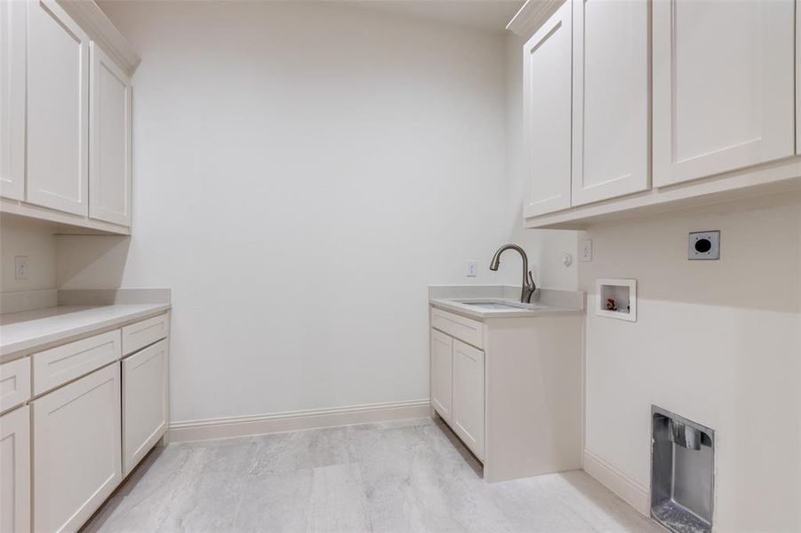 Clothes washing area featuring washer hookup, cabinets, sink, electric dryer hookup, and light hardwood / wood-style flooring