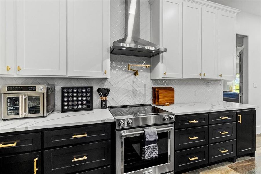 Stunning two-toned cabinetry with hardware that flows throughout....don't miss the pot filler!