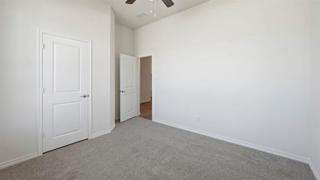 Unfurnished bedroom with carpet and a ceiling fan Unfurnished bedroom with carpet and a ceiling fan