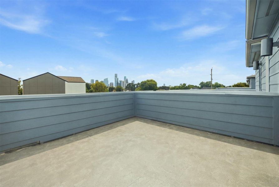 Spacious rooftop terrace with Downtown Houston skyline views, perfect for outdoor relaxation and entertaining.