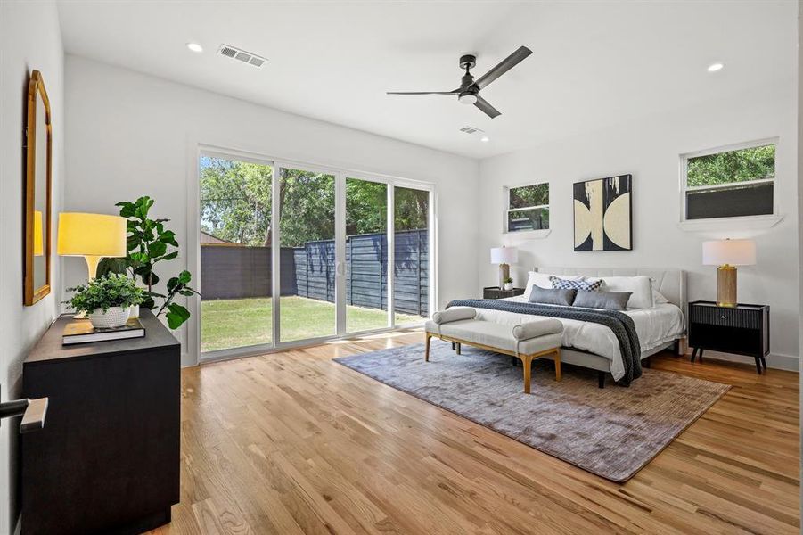 Bedroom with light wood-type flooring, access to outside, ceiling fan, and multiple windows