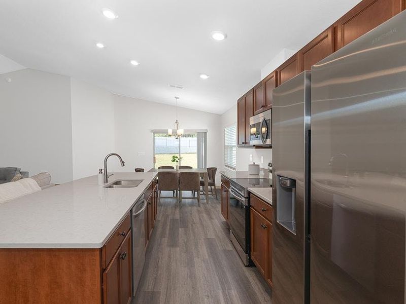 Enjoy a well-appointed kitchen with quartz counters, 36-inch cabinets, Samsung SS appliances, and a walk-in pantry.