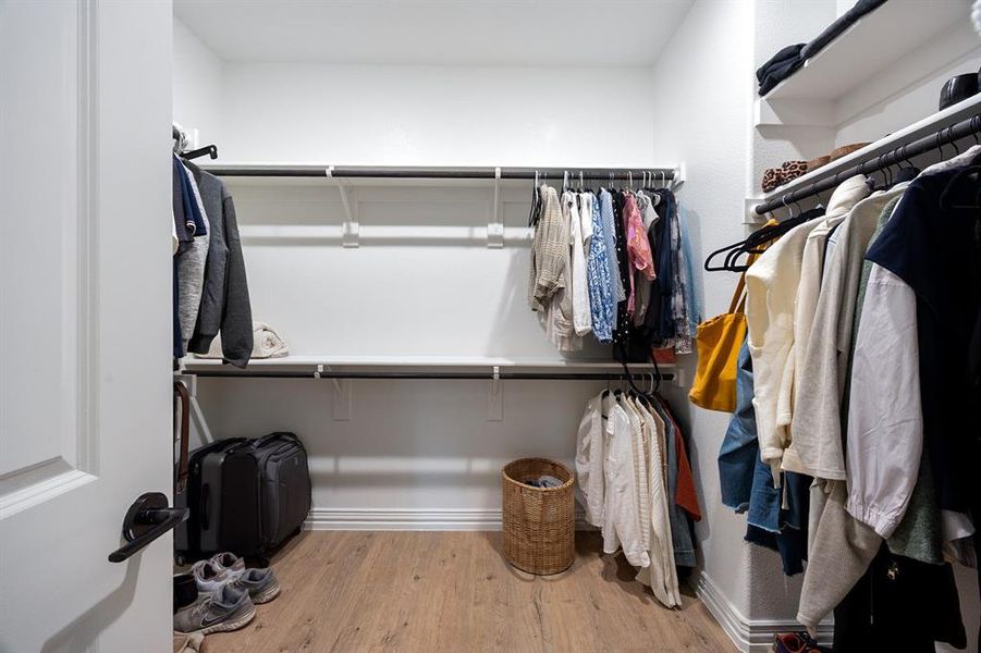 Huge Walk in closet off primary bath featuring light wood-style flooring